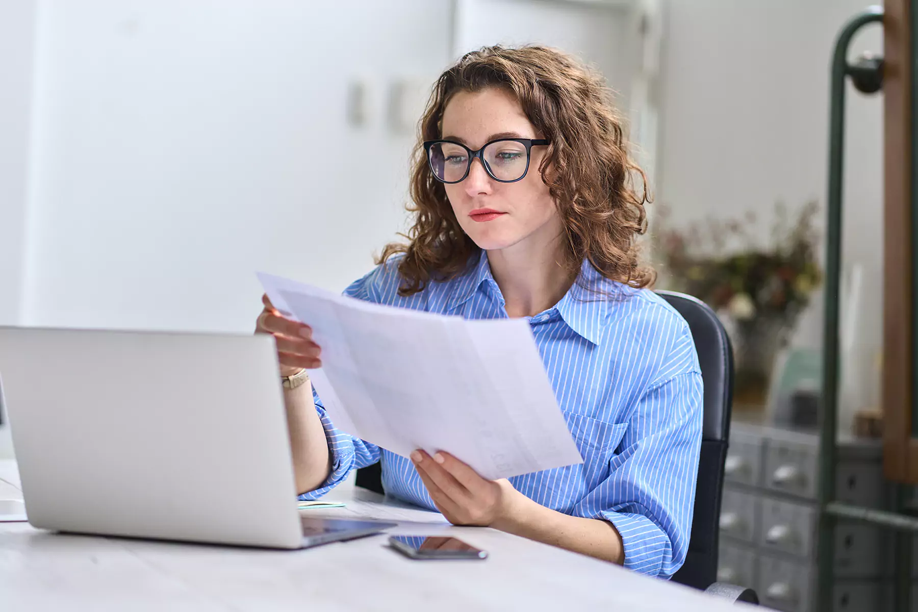 A woman with glasses reading notes